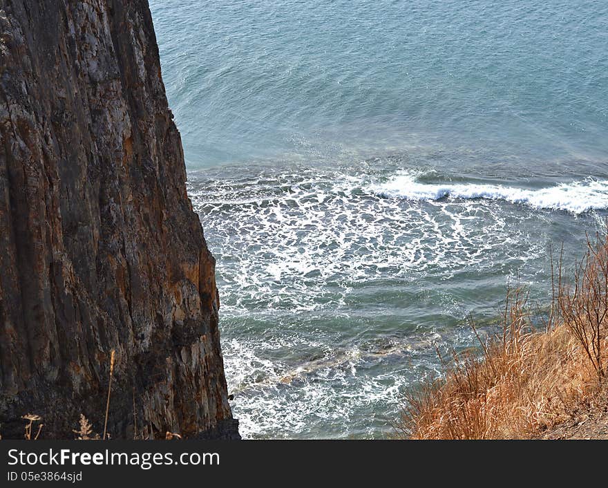 High mountain wall on the sea background