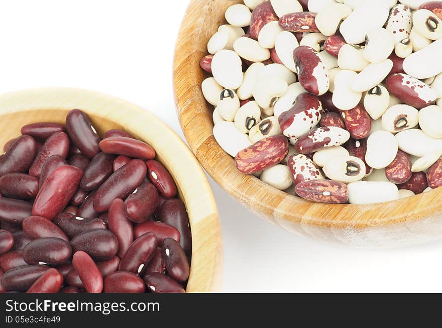 Two Wooden Bowls with Red, White and Variegated Bean on white background. Top View. Two Wooden Bowls with Red, White and Variegated Bean on white background. Top View