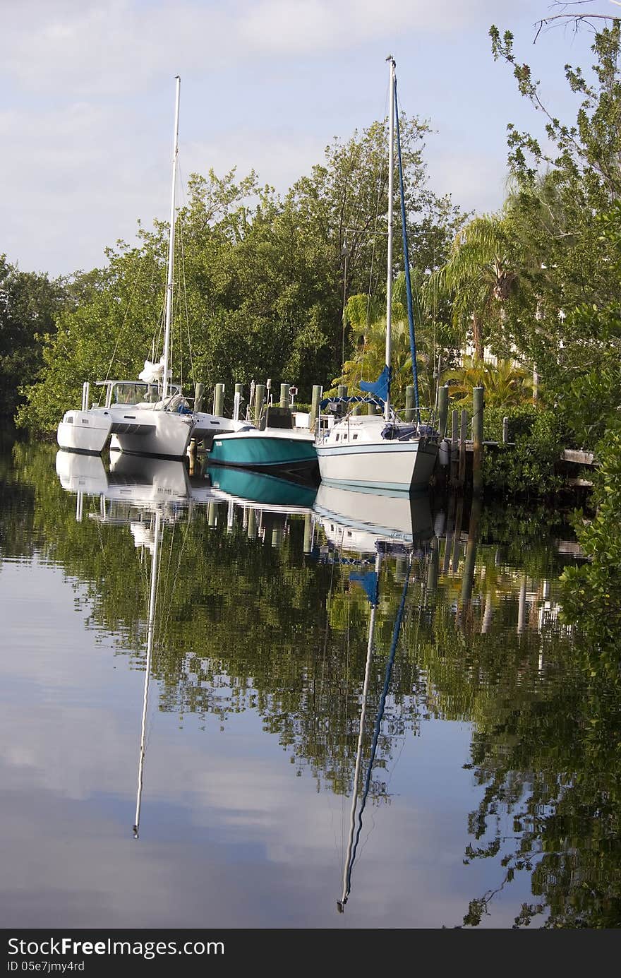 Sailboats rest in a peaceful canal in Key Largo Florida. Sailboats rest in a peaceful canal in Key Largo Florida