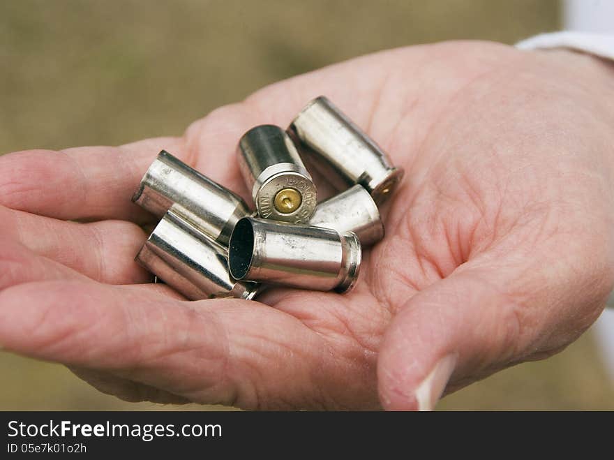 A woman hold spent bragg from a Glock 9mm Handgun after firing. A woman hold spent bragg from a Glock 9mm Handgun after firing.