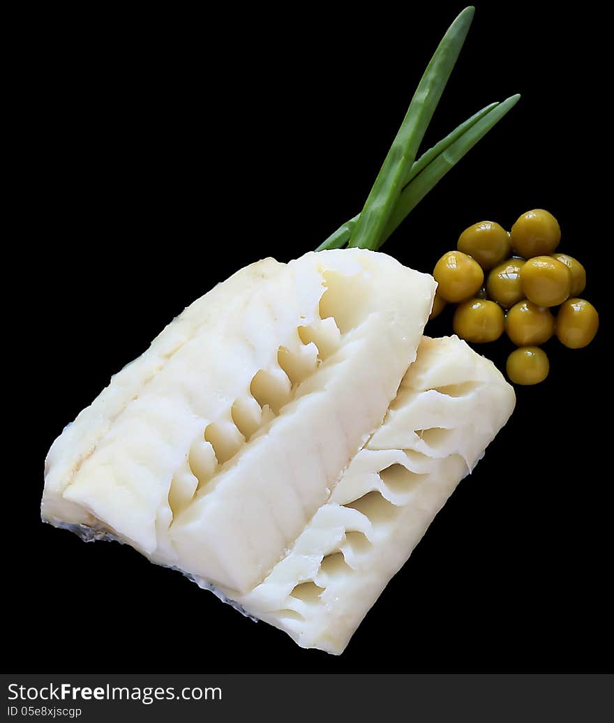 Steamed fish with onion and green peas on a black plate