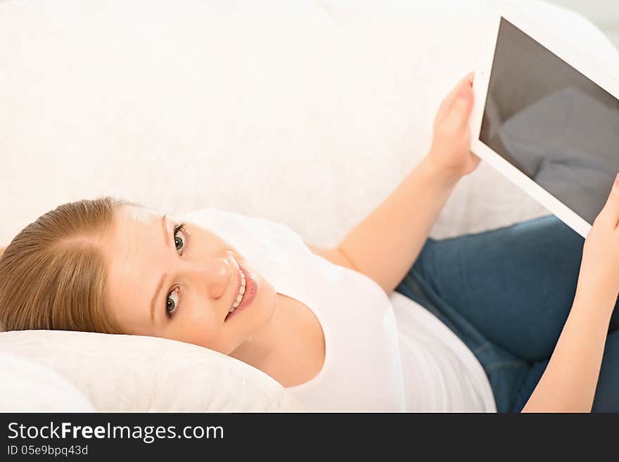 Young beautiful woman relaxing at home with a Tablet PC