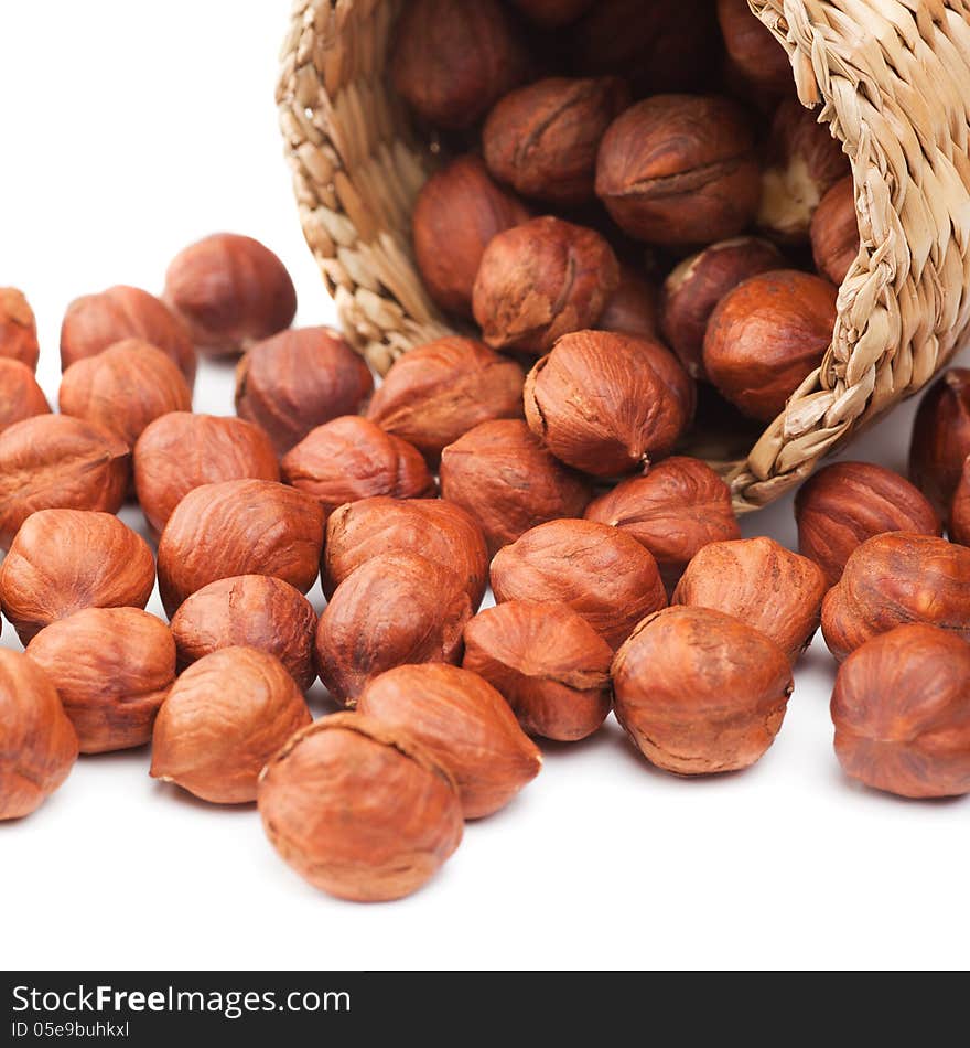 Hazelnuts and basket on white