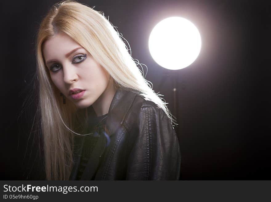 Beautiful blonde with a studio light behind and lens flare studio shot