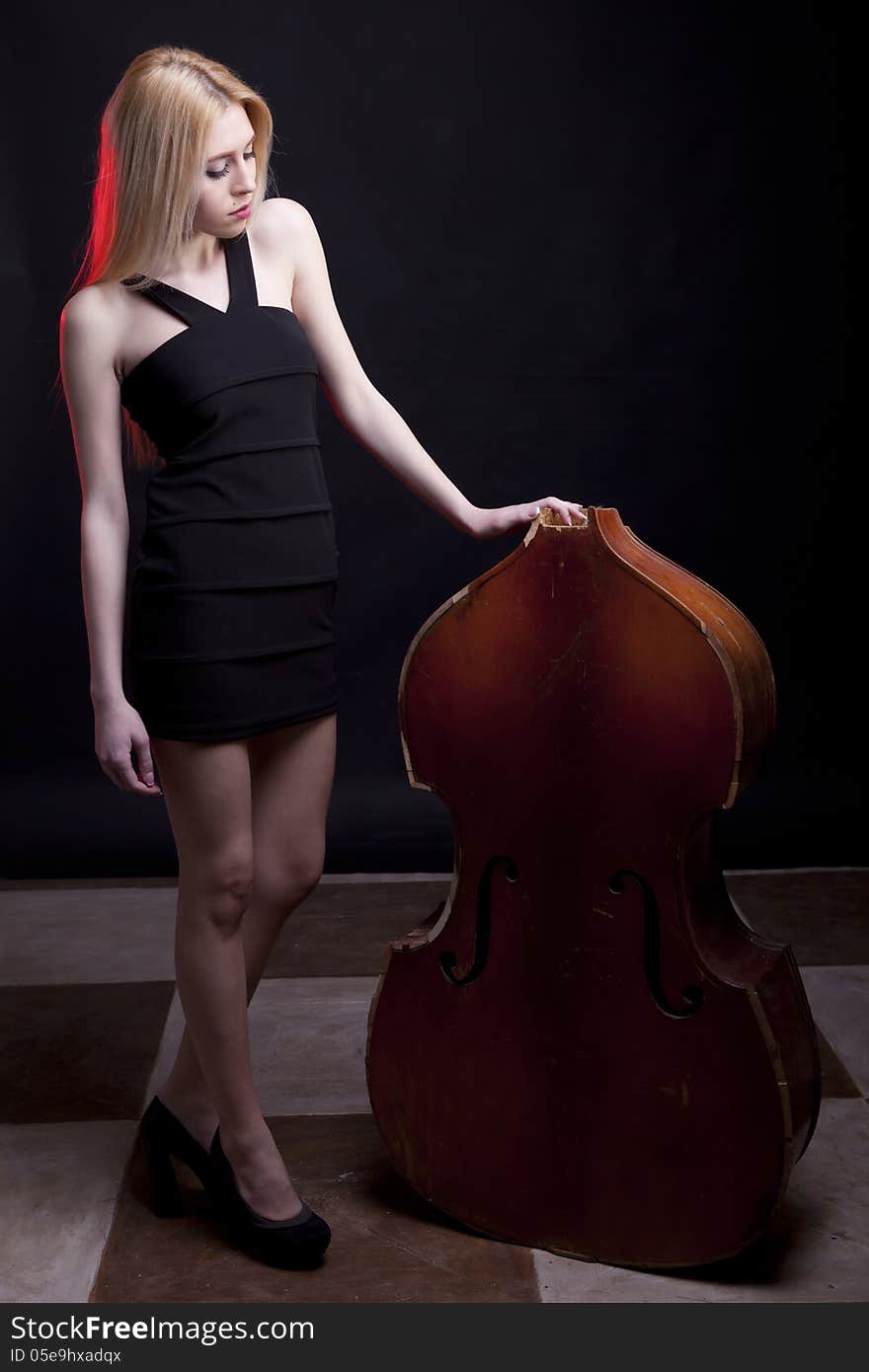 Beautiful model looking at a broken contrabass