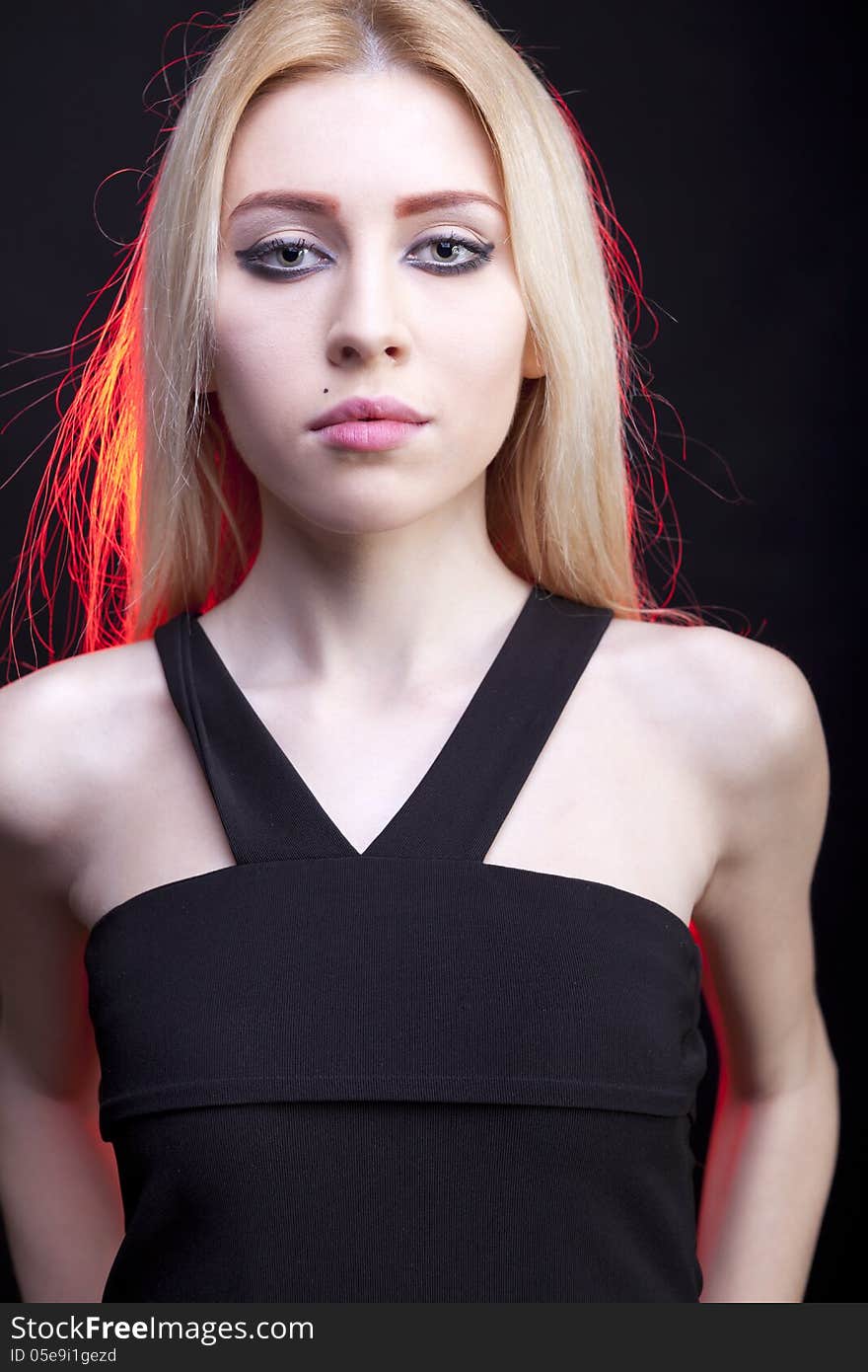 Close up portrait of beautiful girl with a red light behind studio shot