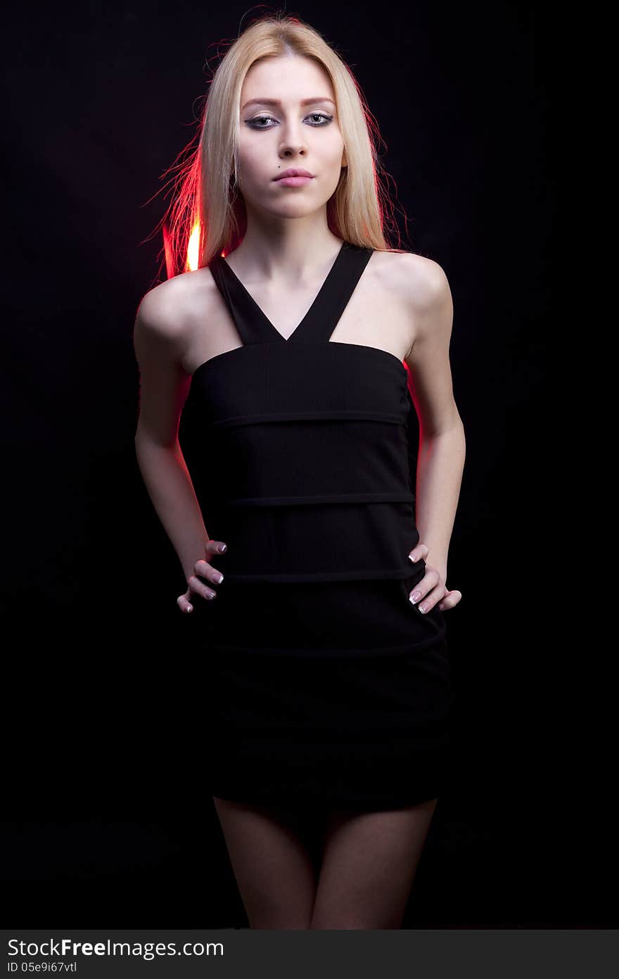 Attractive blonde model with a red light behind studio shot