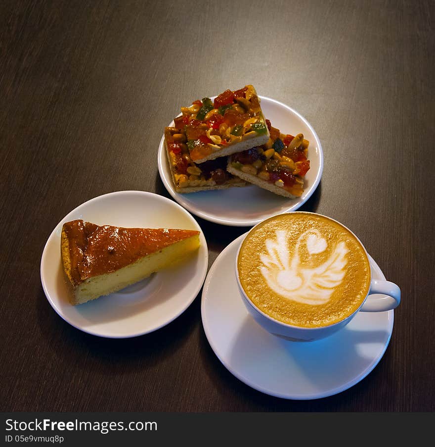 On a wooden table are white plates with cookies and cake. On a wooden table are white plates with cookies and cake