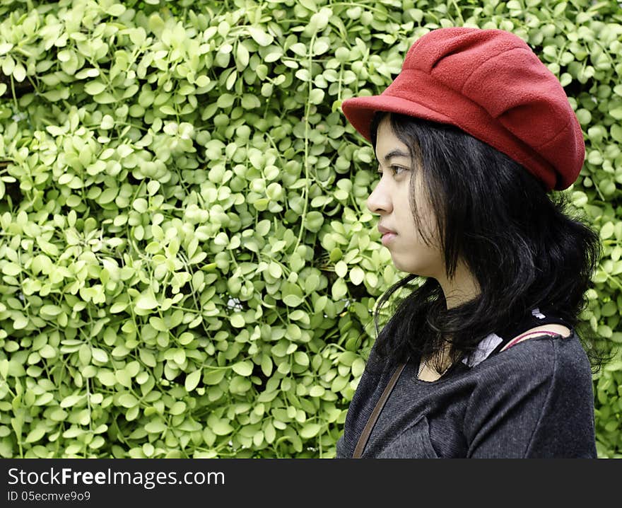 Asian Girl With Red Hat On A Background Of Green Nature