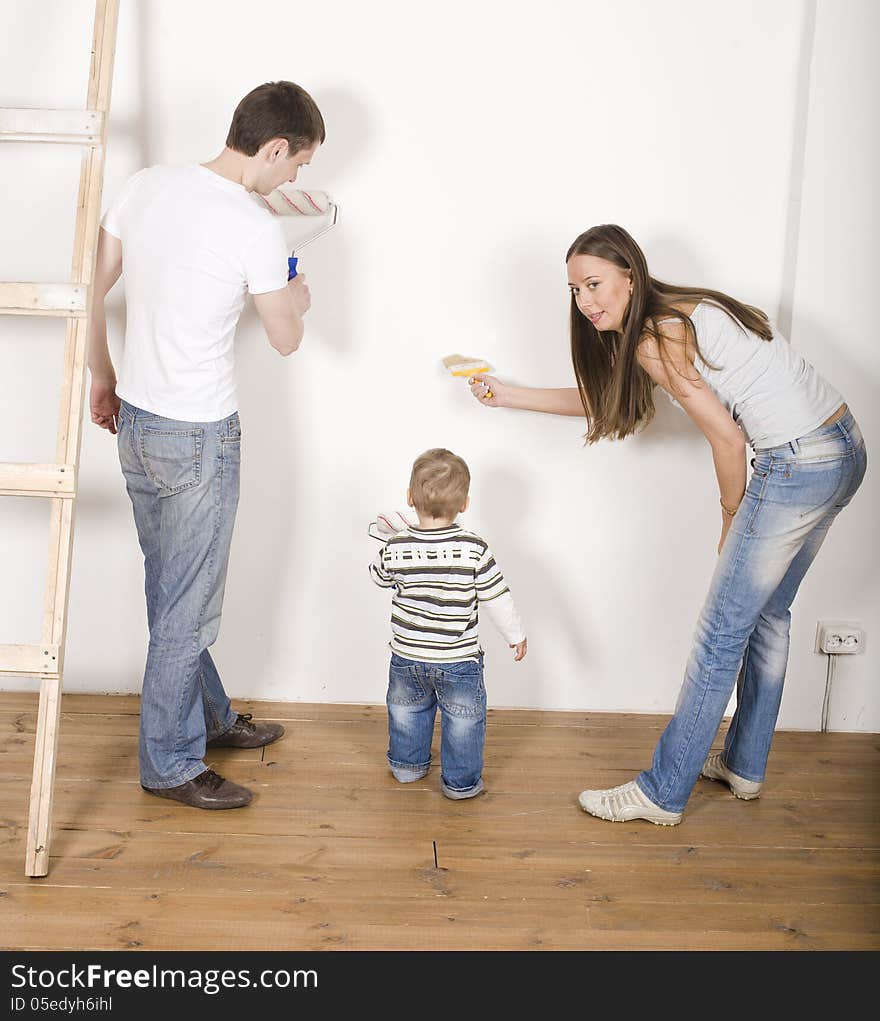 Portrait of happy family doing repair, parents with their son near ladder