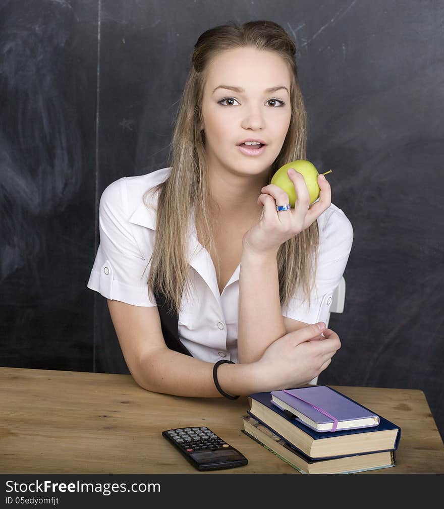 Cute young student near blackboard with copy book calculator pen, copy space