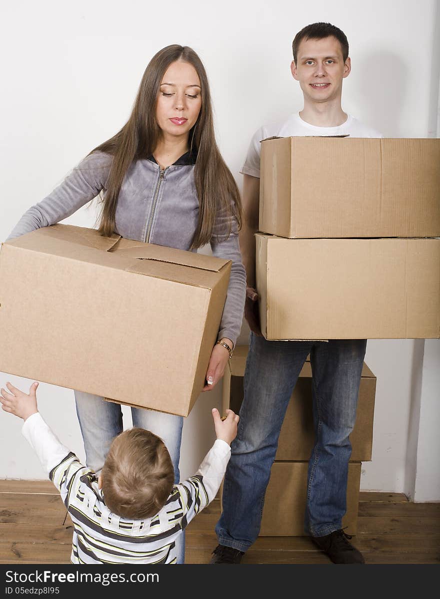 Happy young smiling family in new house playing with boxes