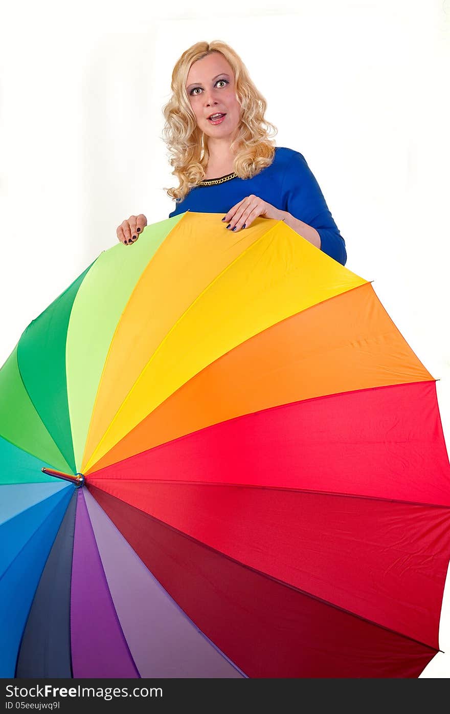 Attractive young blonde woman standing behind a large colored umbrella isolated on white. Attractive young blonde woman standing behind a large colored umbrella isolated on white