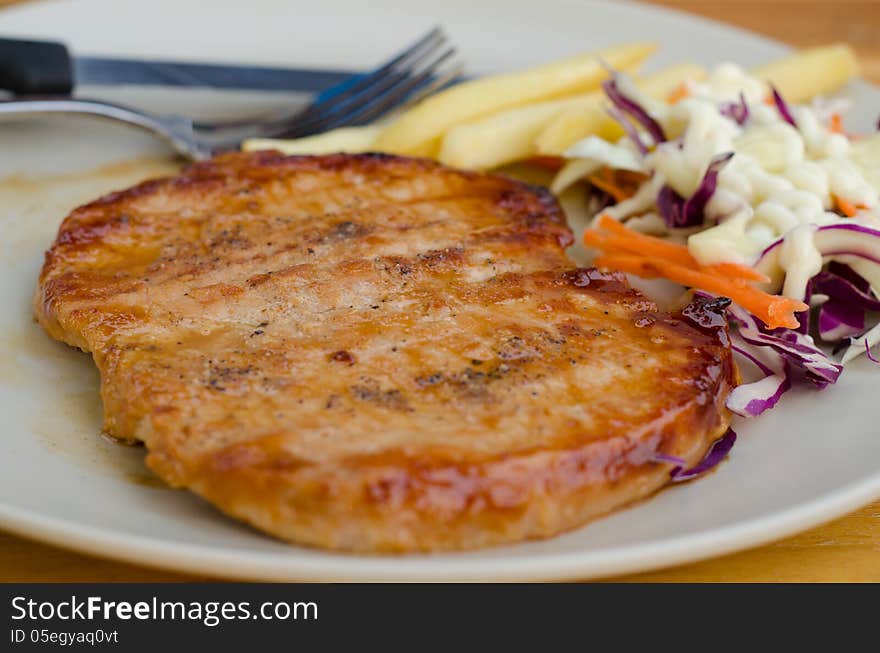 Pork steak with salad and French fries