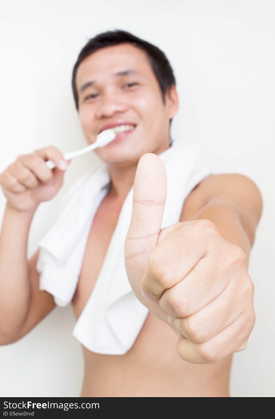 Man Brushing His Teeth And Showing Thumb Up