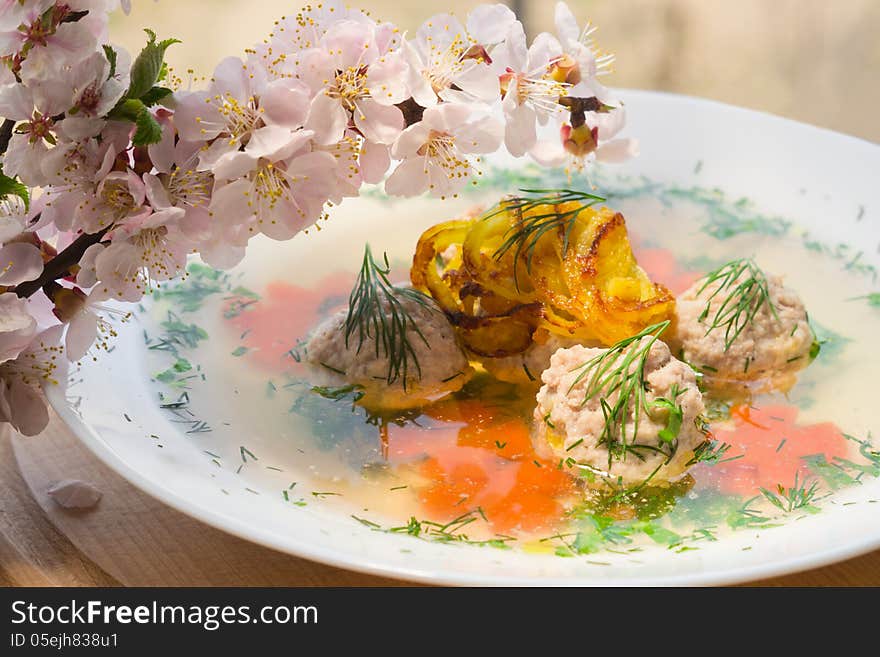 Soup with meatballs and blossoming branch apricots