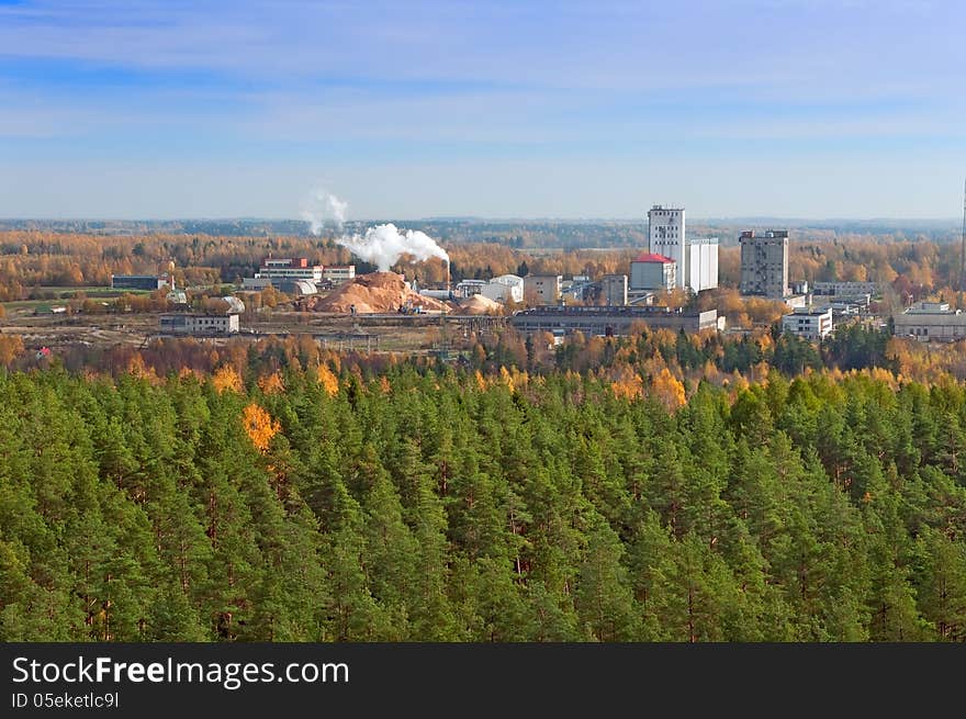 Factory in a green forest polluting the environment