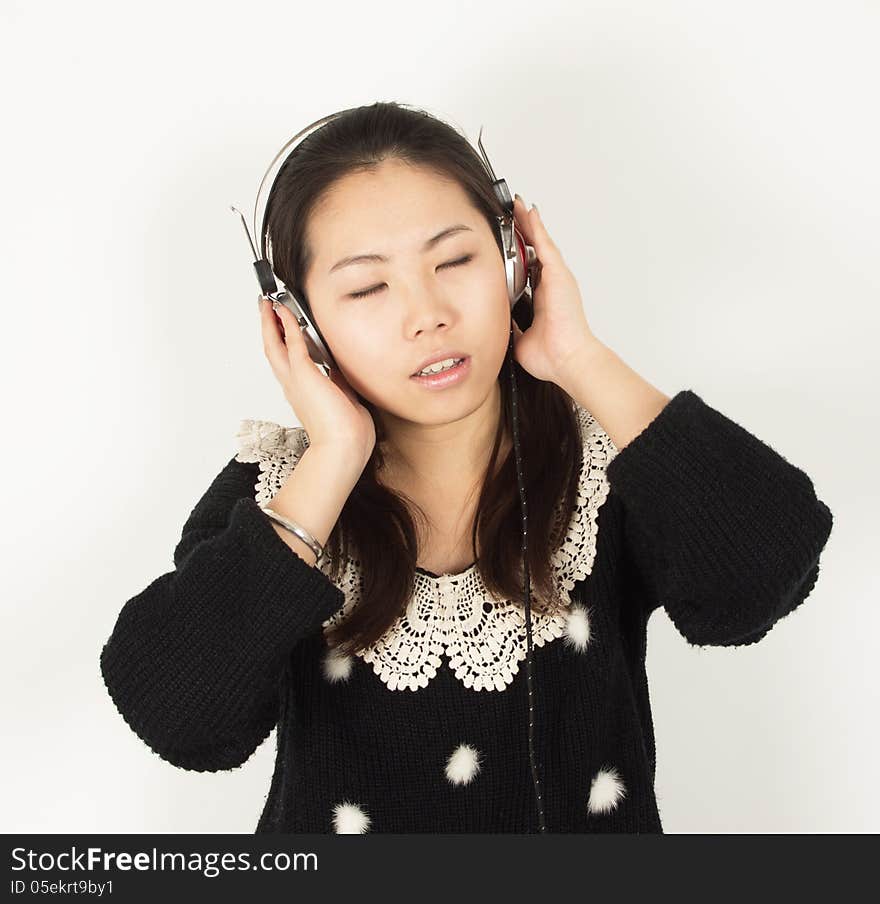 Young woman listening to music with headphones. Young woman listening to music with headphones.