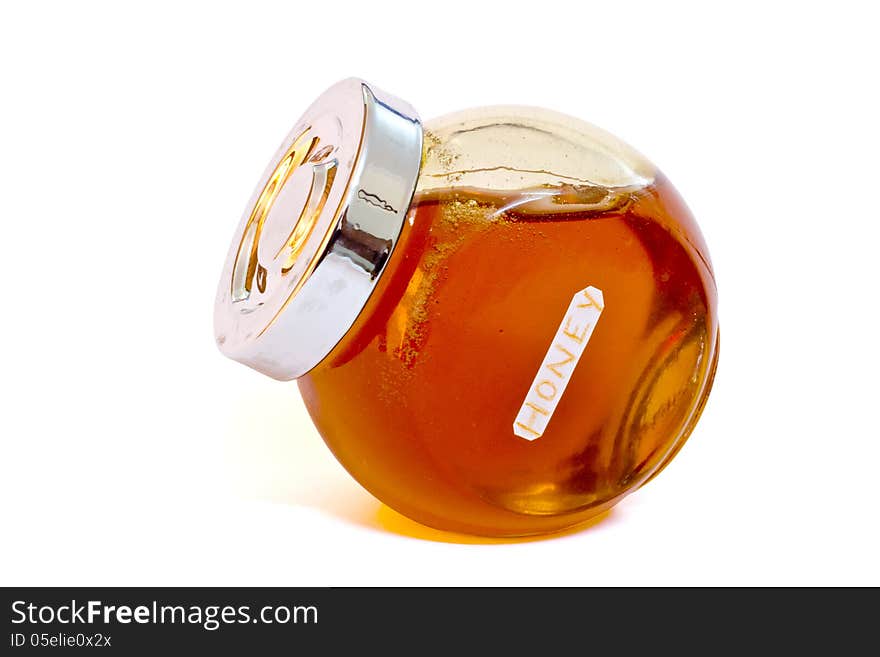 Glass jar of honey on white, with clipping path.