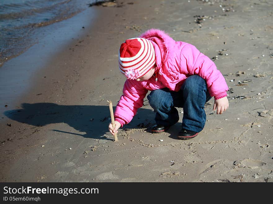 A girl drawing on the sand