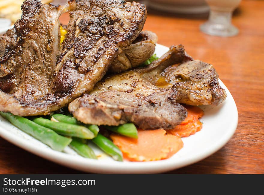 Lamb Chop with carrot slices on a white plate