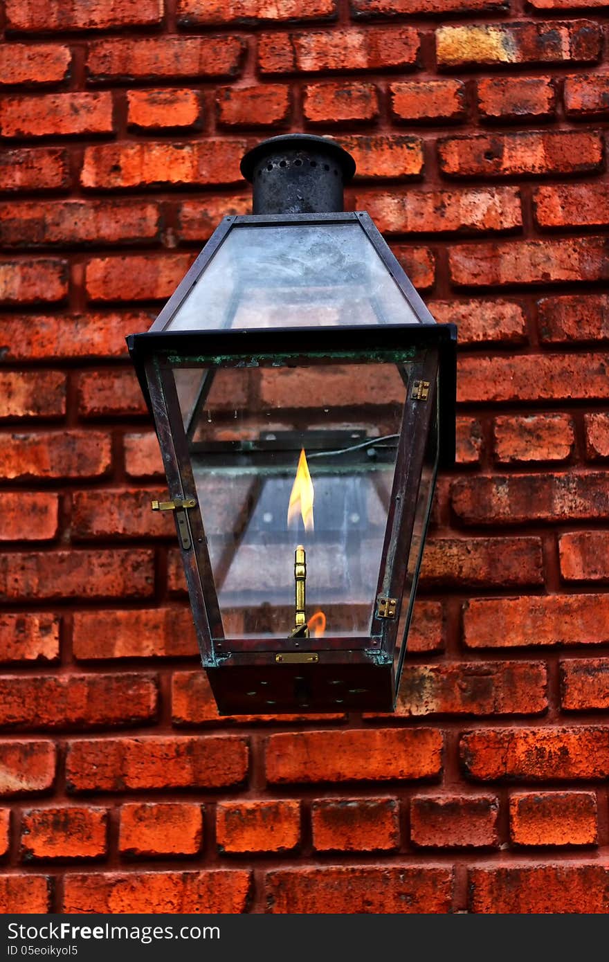 Old gaslight lantern close up on a red brick wall. Old gaslight lantern close up on a red brick wall