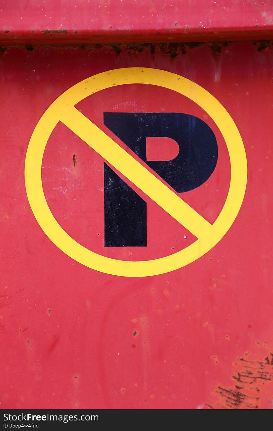 Yellow and black no parking sign on red metal.