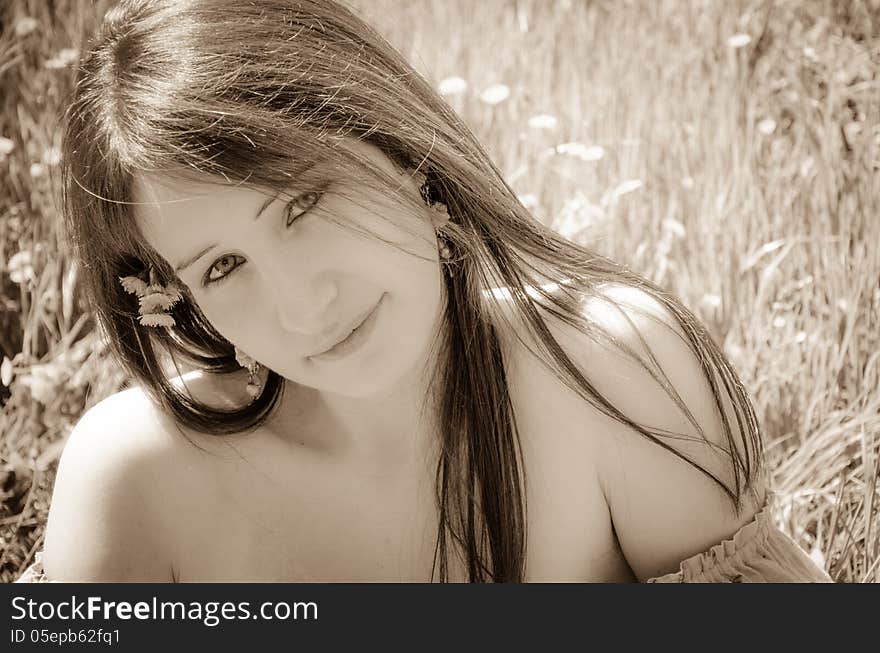 Beautiful young woman face with flower on hair.