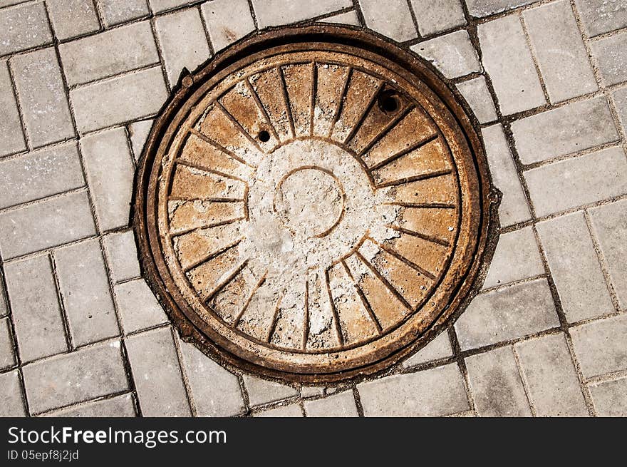 Rusty manhole on road. close-up.