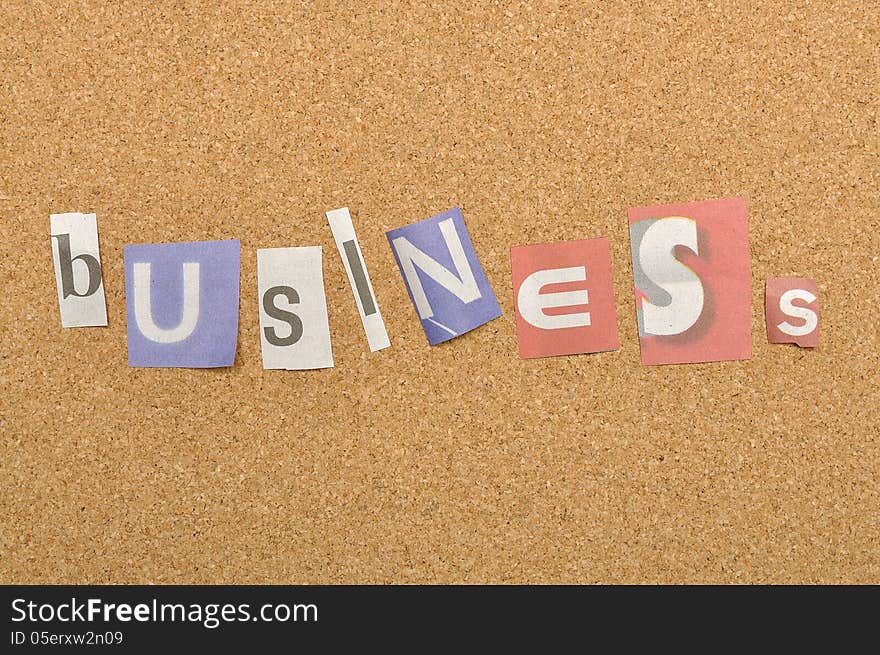 Business word made from newspaper letter shot over pinboard background