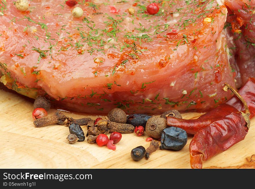 Marinated Raw Pork with Herbs, Dill and Spices closeup on Wooden Cutting Board