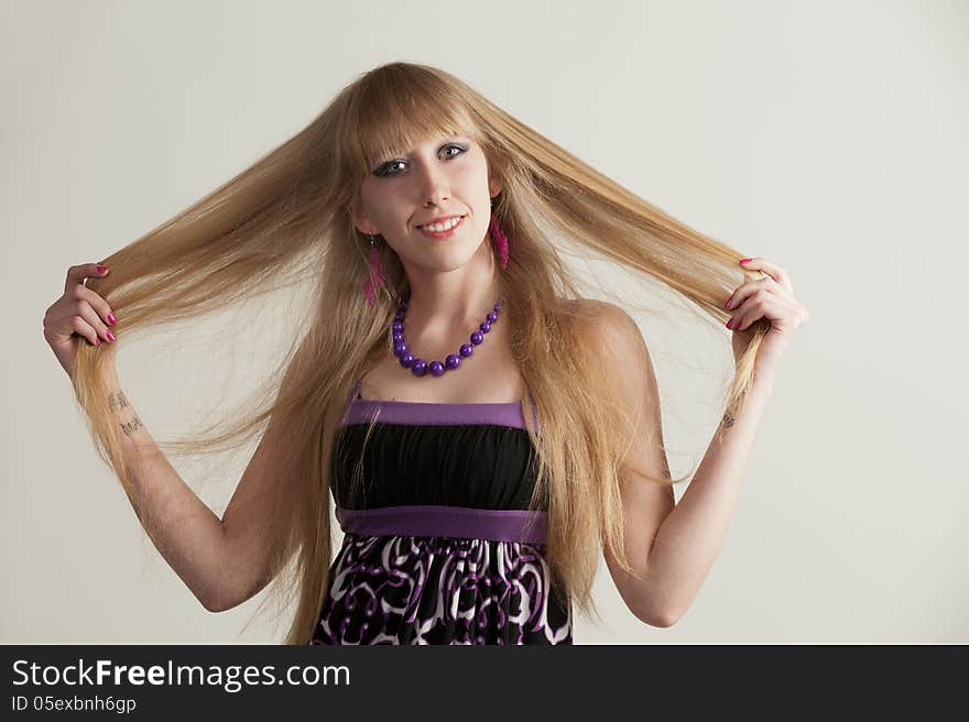 Portrait of a pretty young girl with long hair posing in studio on light background. Portrait of a pretty young girl with long hair posing in studio on light background