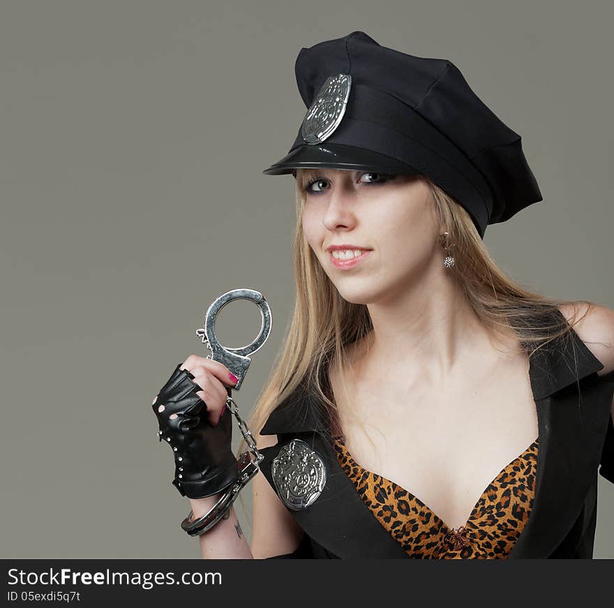 Portrait of a seductive girl in police uniform showing excellent hape in the studio. Portrait of a seductive girl in police uniform showing excellent hape in the studio