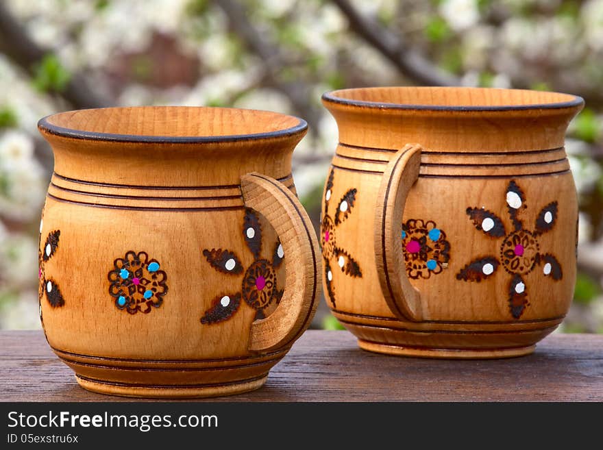 Two wooden mugs with an ornament on a soft background