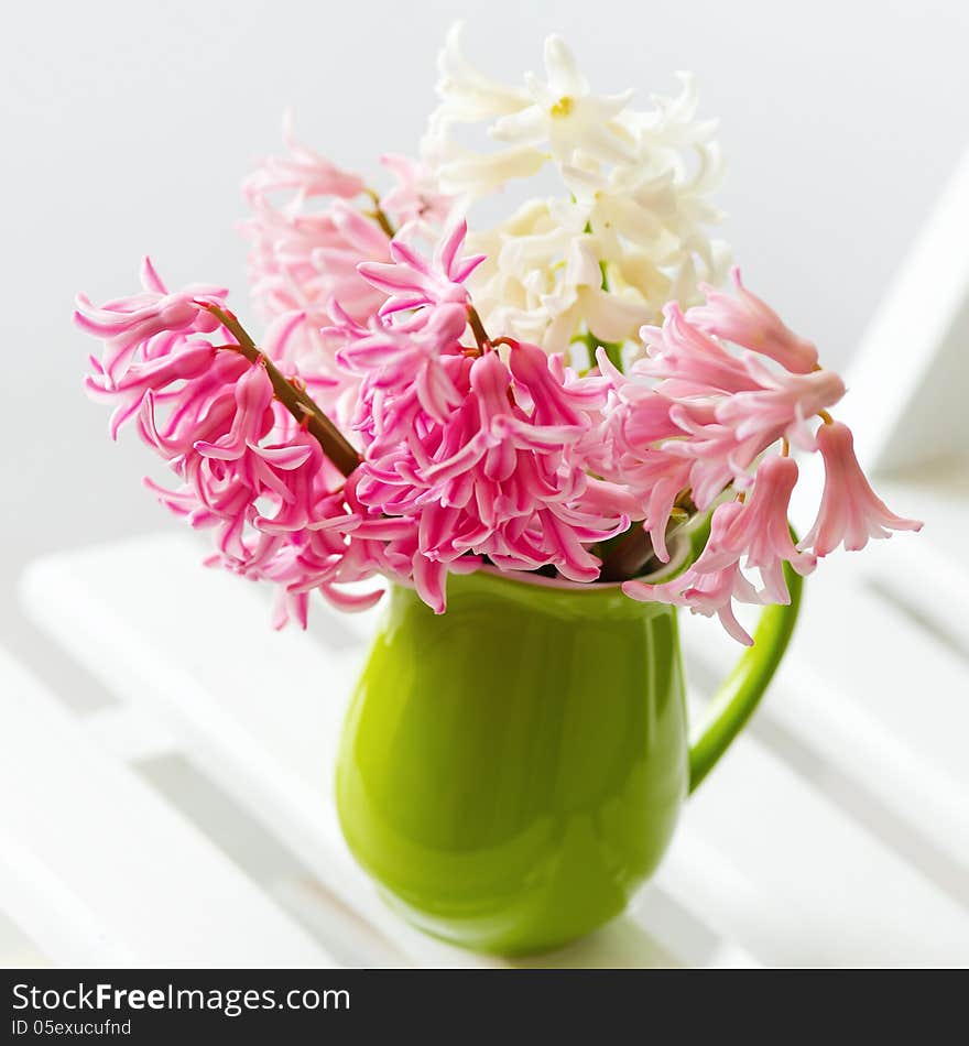 Still life with spring pink and white flowers in a bright green pot. Still life with spring pink and white flowers in a bright green pot