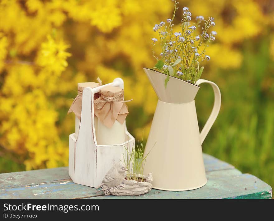 On a yellow background with a jug of wild flowers and bottles. On a yellow background with a jug of wild flowers and bottles