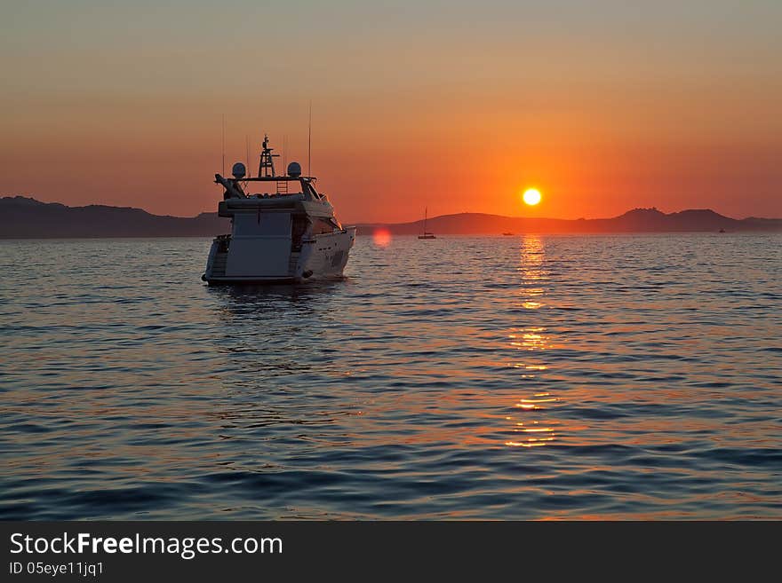 Private motor yachts rest in the bay at sunset