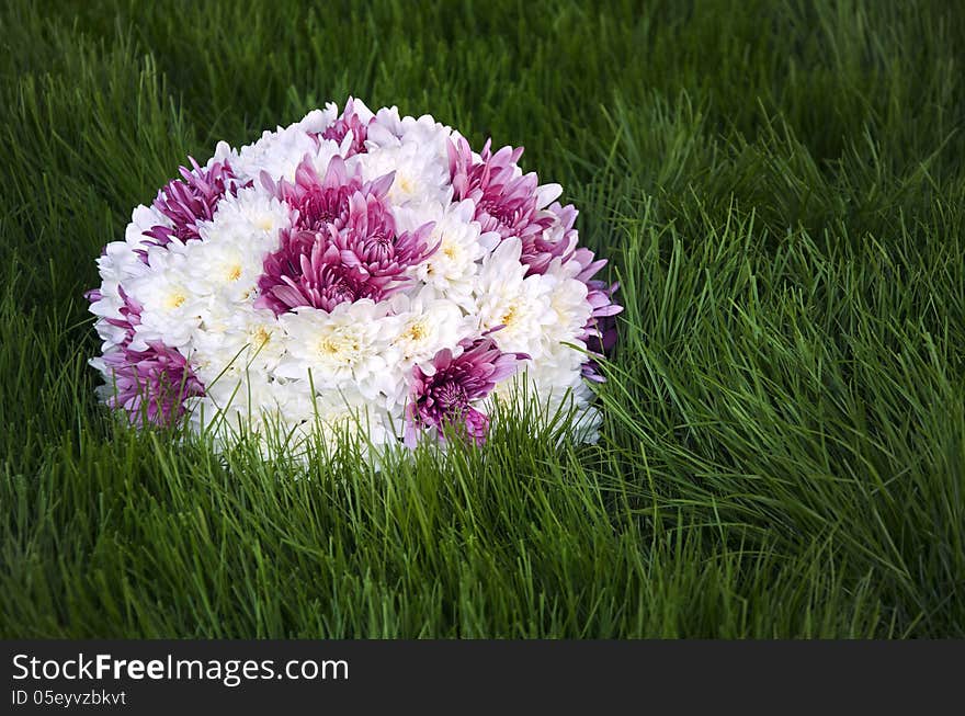 White an purple flowers ball on fresh grass