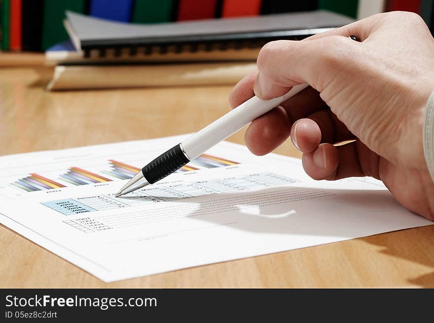 Man's hand signing document on the table