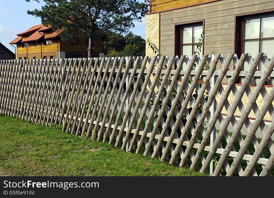 Wooden village house behind the fence. Wooden village house behind the fence