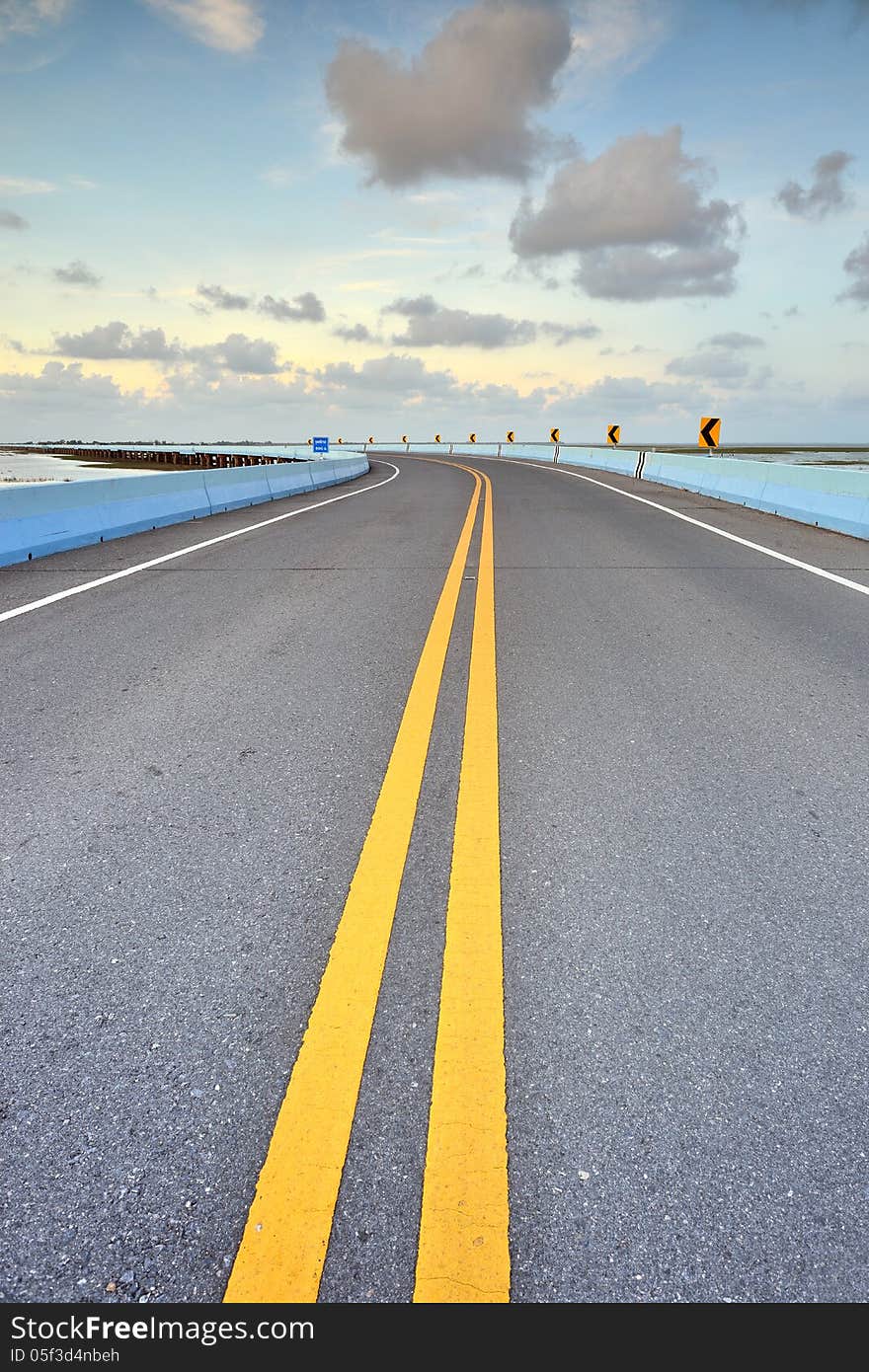 Asphalt road to horizon in cloudy sky