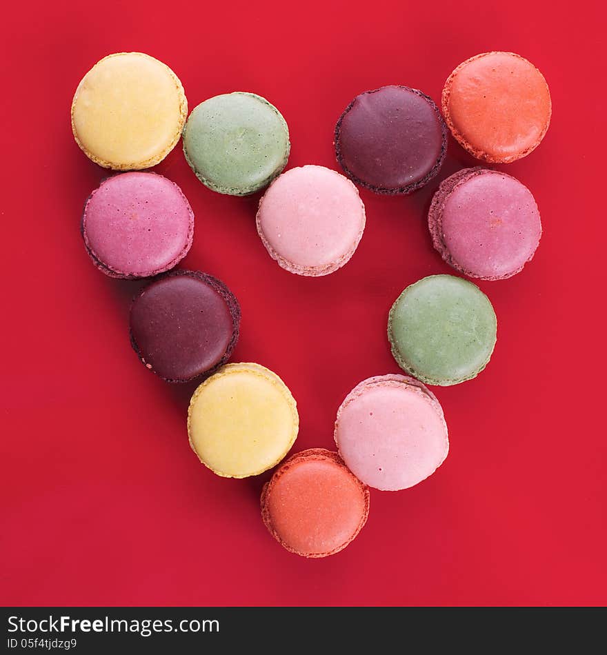 Picture of different colored macaroons on a red background