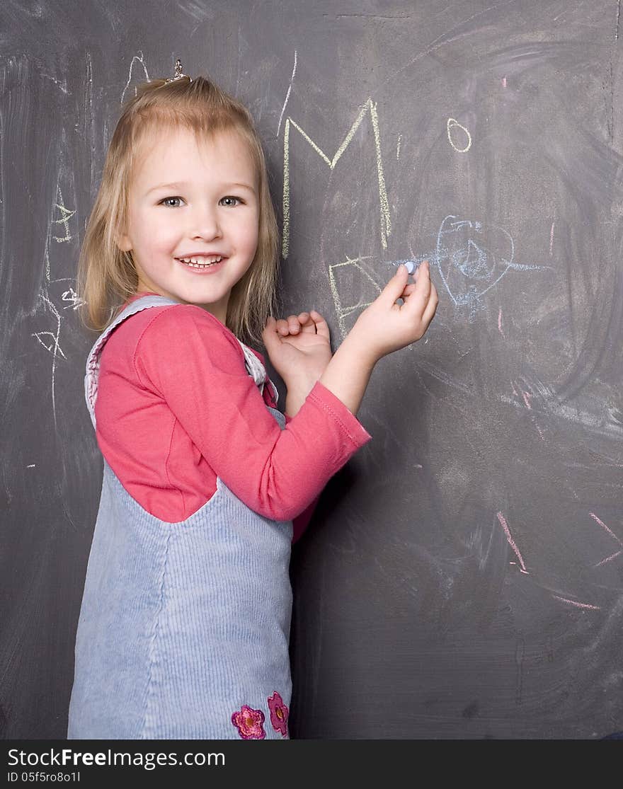 Portrait of little cute girl near blackboard