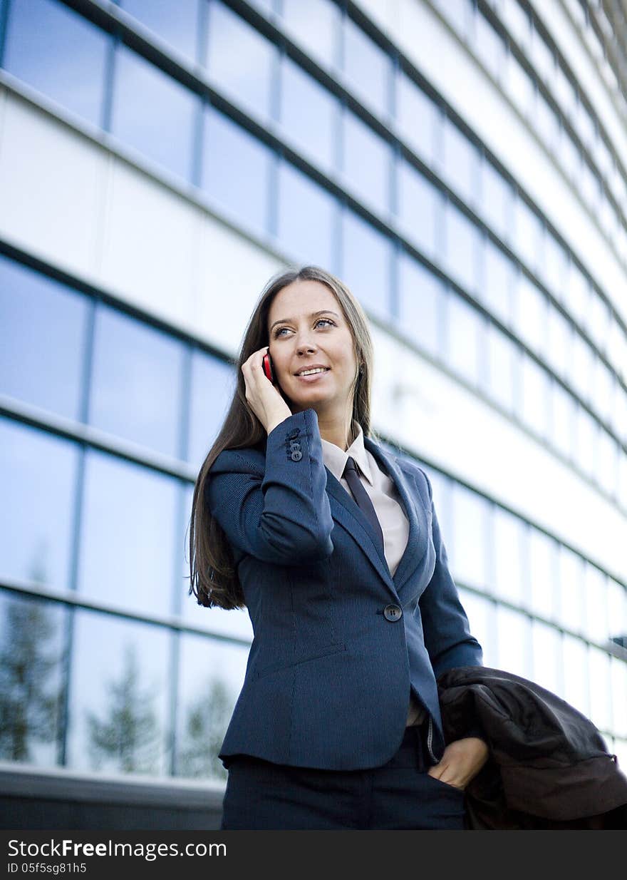 Portrait Of Pretty Young Business Woman Talking On Phone Near Building