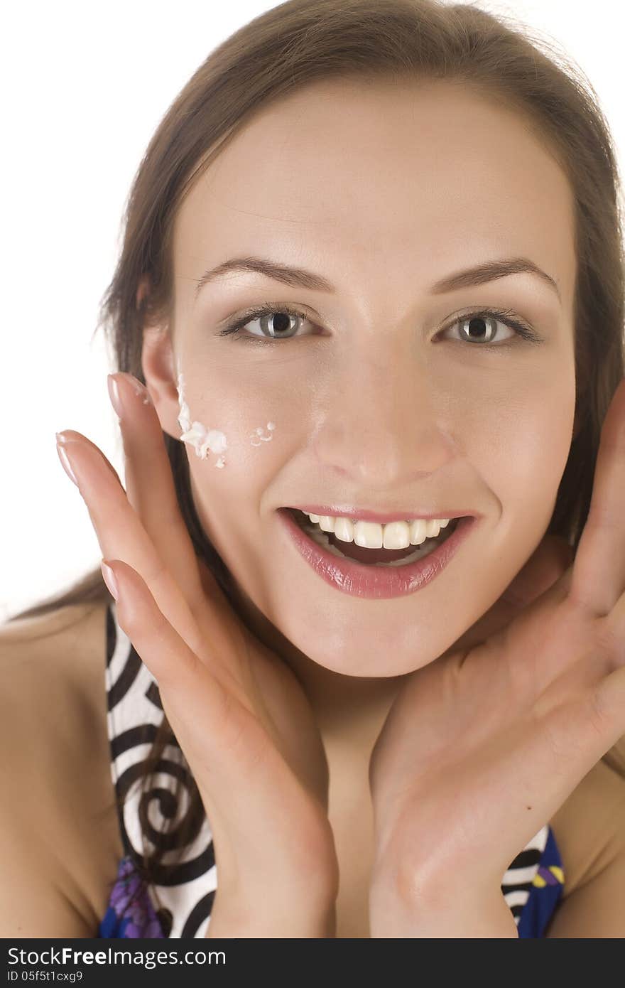 Stock photo portrait of beautiful young woman touching her face with cream, isolated