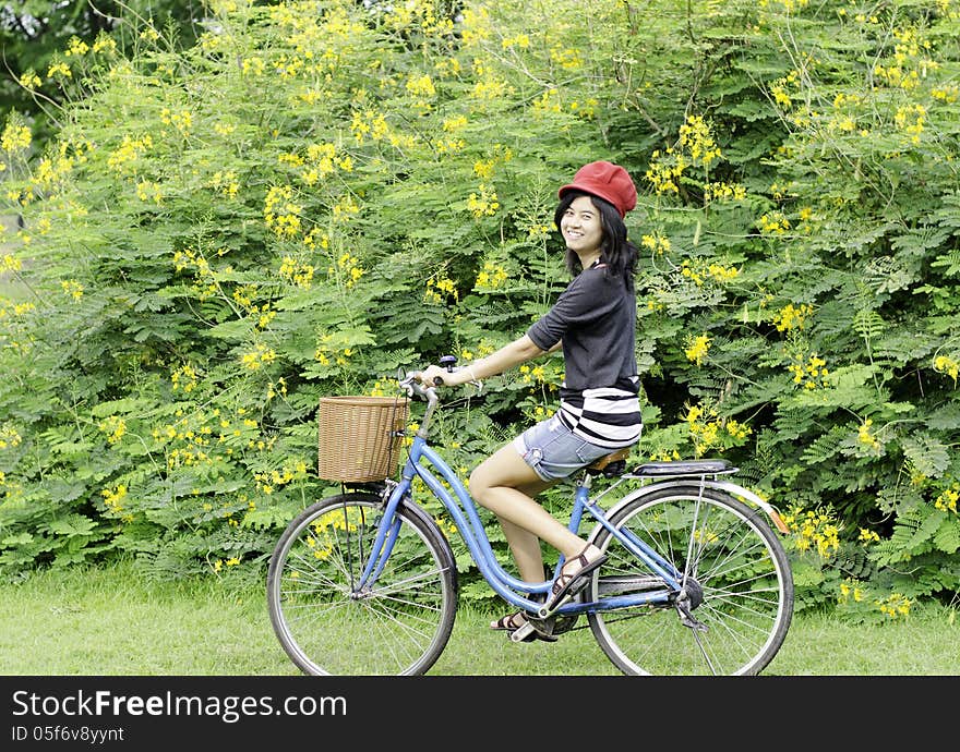 Happy smiling girl riding a bicycle in the park