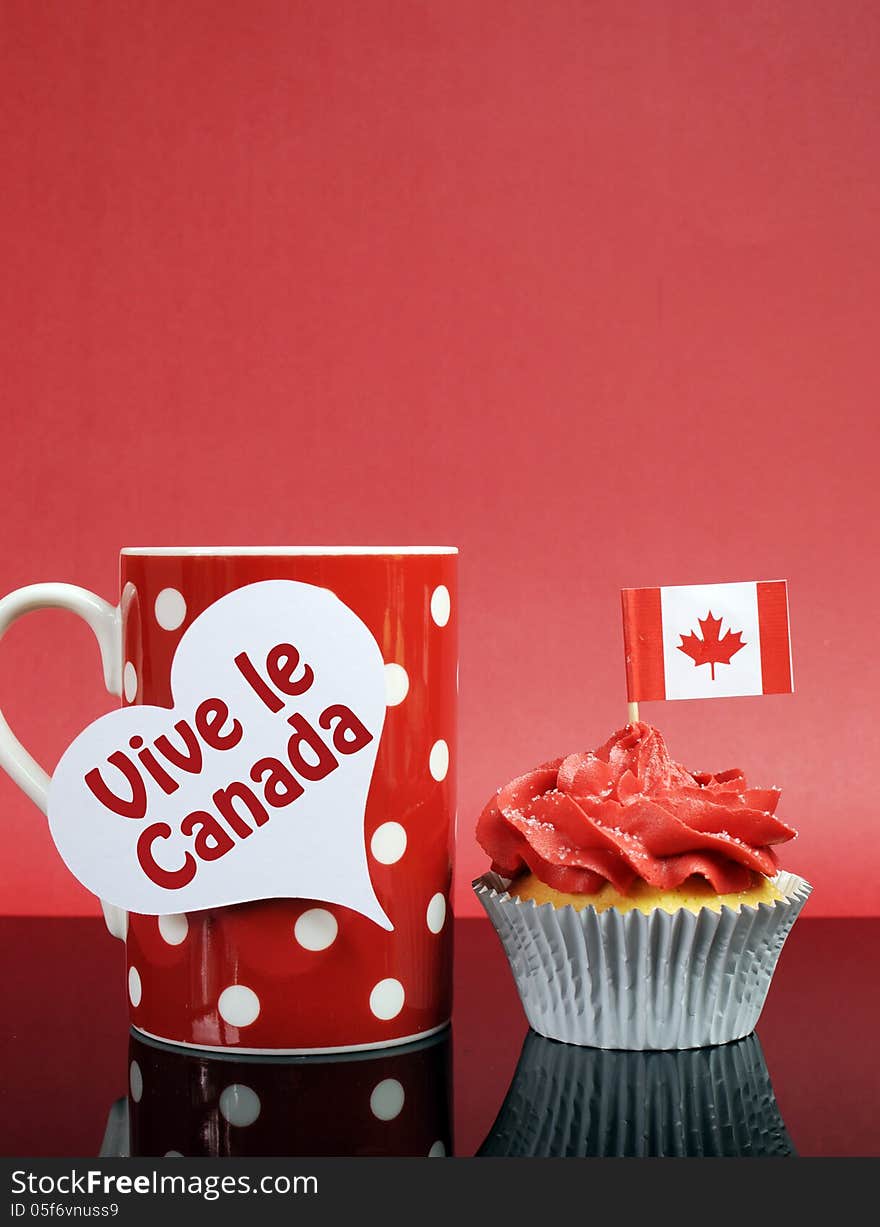 Red and white theme Canadian cupcake with maple leaf flag and red polka dot coffe mug with Happy Canada Day, Vive Le Canada, or copy space for your text here. Vertical with copy space.