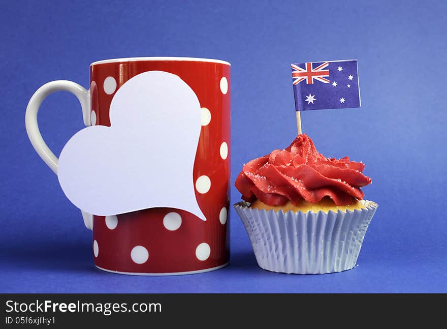 Australian theme red, white and blue cupcake with national flag and red polka dot coffee mug and white heart tag for your text here, for Australia Day, Anzac Day or national holiday against a blue background. Australian theme red, white and blue cupcake with national flag and red polka dot coffee mug and white heart tag for your text here, for Australia Day, Anzac Day or national holiday against a blue background.