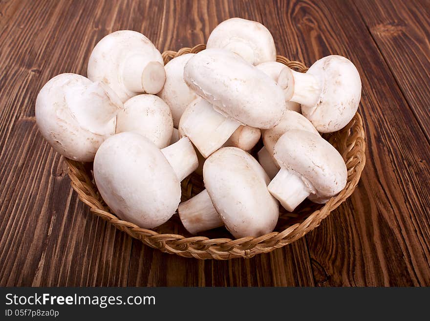 Mushrooms in a basket on a wooden background