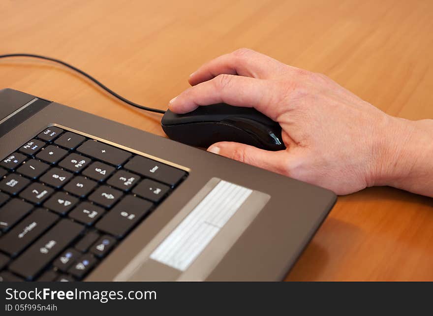 Man's hand with a black computer mouse. Man's hand with a black computer mouse